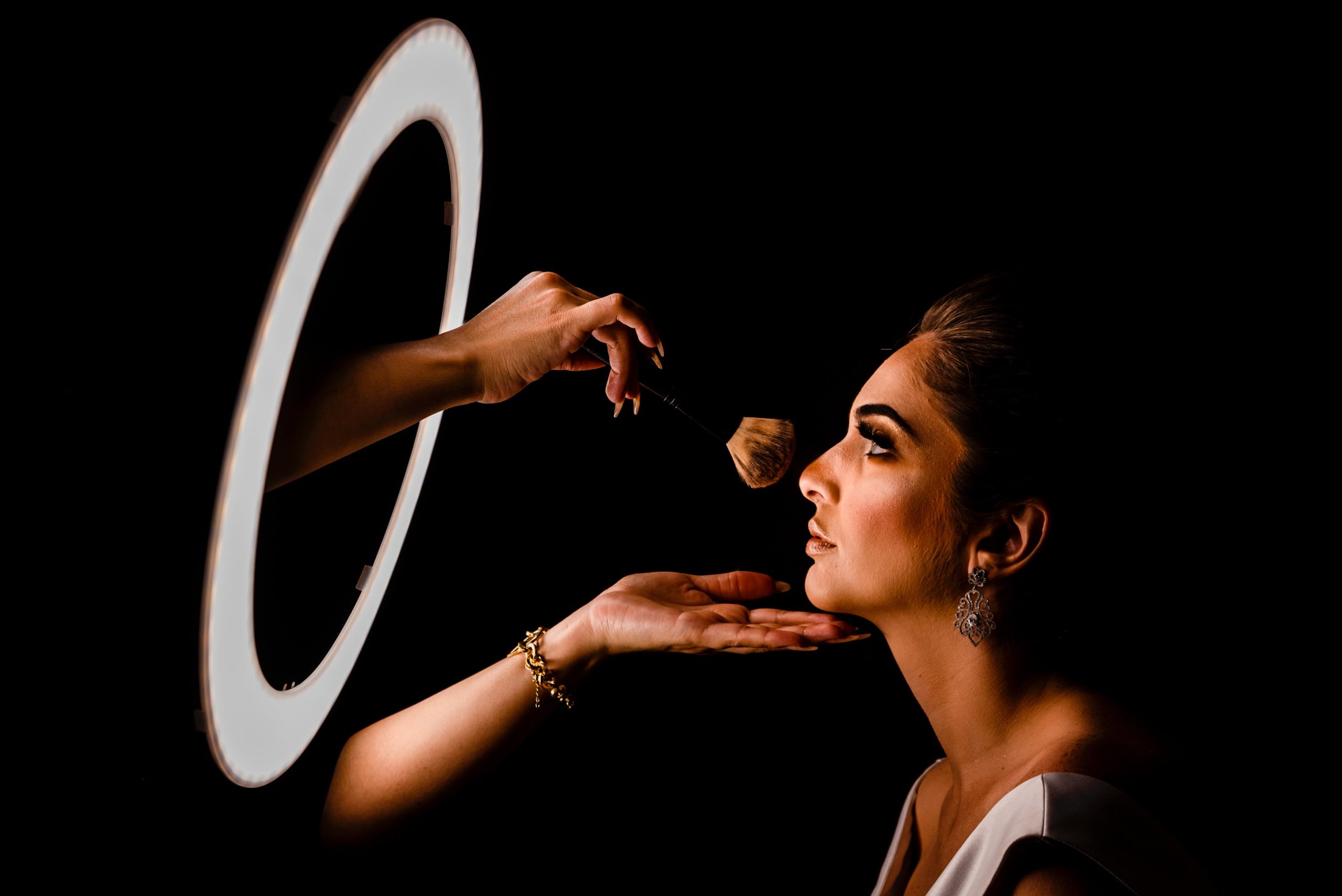 Woman Having Her Makeup Done in Front of a Ring Light